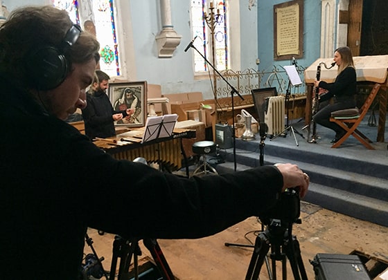 London Sinfonietta's Digital Productions Manager Adam Flynn filming musicians in Coventry Cathedral