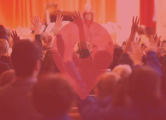 School children raising their hands in the air, with a red pindrop overlayed on the image.