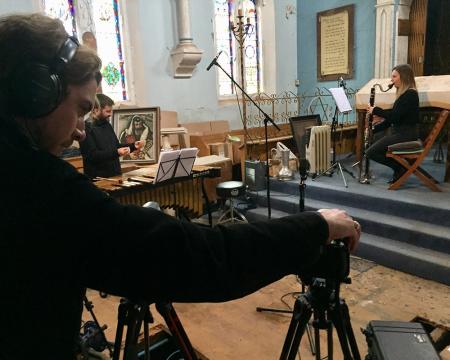 An image of a cameraman filming London Sinfonietta musicians in a synagogue