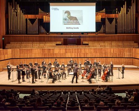 A wide shot of young musicians performing at the Royal Festival Hall