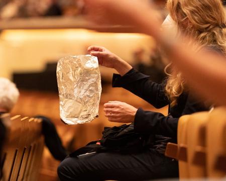 A close-up shot of an audience member holding a piece of foil in the performance of Night Shift (c) Astrid Ackermann