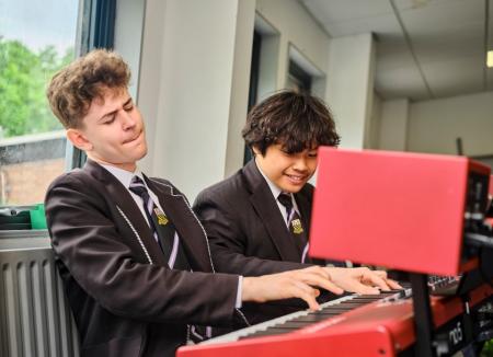 Two St Ignatius students playing keyboard 